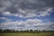 Empty meadow pasture for cows, cattle, lambs. On a cloudy but sunny summer day.