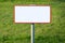 Empty metal signboard, grass in background