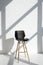 Empty modern chair in room, stine sunlight, white walls. Minimalistic interior, concept of cleanliness, loneliness, calm,