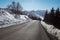 Empty mountain road descent on Alps, blue sky