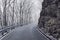 Empty mountain road in winter, rock at the roadside