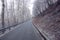 Empty mountain road in winter, rock at the roadside