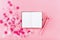 Empty note pad on pink festive background with confetti and sparkles.