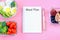 Empty notepad with inscription meal plan on pink background and containers with food.