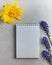 An empty Notepad, purple and yellow flowers. The concept of a greeting card, an invitation to a holiday. Copy space