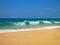 Empty ocean beach with clear sand and blue waves, Koggala, Sri Lanka