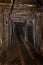 Empty old abandoned mine shaft with wooden timbering and rusty railway