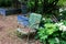 Empty old green metal chair against a blue block wall, aging death grief absence concept