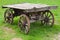 Empty old rural wooden wagon on green summer grass