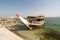 Empty old traditional dhow ship docked by the shore at Doha Port