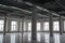 Empty open space room in old factory building with rows of columns, big windows and pipes under the beton ceiling