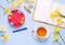 Empty Opened Notebook Cup of Tea Red Clock Yellow Daffodils on Light Blue Background. Woman working desk with cozy breakfast. Top