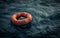 An empty orange inflatable life raft adrift on the ocean waves, symbolizing isolation and danger.