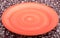 Empty orange plate on textured background