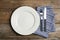 Empty ornate plate with cutlery and napkin on table, flat lay