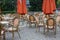 Empty outdoor cafe with closed umbrellas. Street cafe with empty tables and chairs. Restaurant furniture concept.