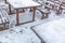 An empty outdoor cafe covered in snow