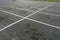 Empty outdoor dirty parking lot space marked with white lines