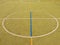 Empty outdoor handball playground, plastic light green surface on ground and white blue lines.