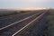 Empty Pair of Railroad Tracks at Sunrise on the Prairie