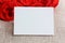 Empty paper card close-up and red roses