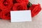 Empty paper card close-up and red roses. mock up