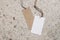 Empty paper gift tags, price labels with ropes on terrazzo background. Marble stone texture. Modern template, branding