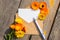 An empty paper postcard, an envelope and a calendula flower on a wooden background, a postcard layout