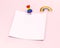 Empty paper square with copy space for your text pinned with rainbow colored pin and gay pride rainbow above. Isolated on pastel