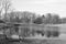 Empty park bench facing windmill and pond