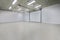 Empty parking garage, warehouse interior with large white gates and gray tile floor