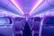 Empty passenger airplane seats in the cabin in neon light