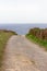 Empty path to the sea. Camino de Santiago concept. Countryside landscape. Trail to the beach along the meadow. Walk and travel.