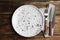 Empty patterned plate with cutlery and napkin on table, flat lay