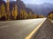 An empty paved road on Karakoram highway against snow capped mountain range in autumn.