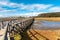 Empty Pedestrain Bridge over a Creek at Low Tide and Blue Sky