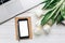 Empty phone screen and laptop and tulips on white wooden rustic