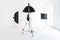 Empty photo studio with lighting equipment. Photographer workplace interior with professional tool set gear. Flash light