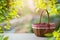 Empty picnic basket on wooden table over green leaves background. Spring and easter mock up for design