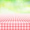 Empty picnic gingham tablecloth, green background