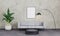 Empty picture frame in loft living room. Picture mockup. Modern interior living room with grey concrete wall, sofa, black lamp