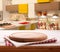 Empty pizza board with tablecloth on the table and kitchen interior blurred background