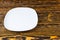 Empty plain white plate on a wood background