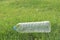 Empty plastic bottle trashed on a green field
