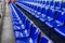 Empty plastic chairs in the stands of the stadium. Many empty seats for spectators in the stands. Empty plastic chairs seats for