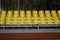 Empty plastic yellow seats at stadium, open door sports arena