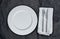 Empty plate and cutlery on black tissue paper