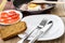 Empty plate, slices tomatoes, bread and prepared bacon and eggs