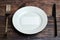 Empty plate on table with cutlery and blank business card, top view. Message for visitor of restaurant or cafe. Business lunch