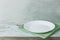 Empty plate on tablecloth on wooden table over grunge